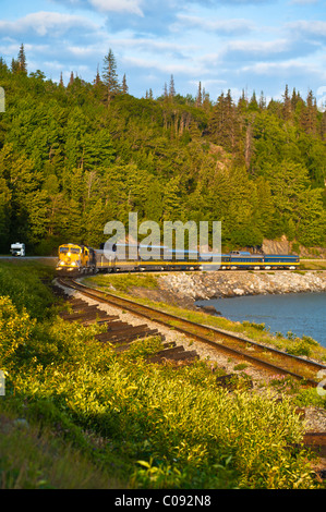 An Alaska Railroad passenger train rounds a corner along Turnagain Arm near Bird Creek, Southcentral Alaska, Summer Stock Photo
