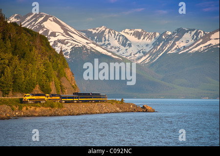 An Alaska Railroad passenger train rounds a corner along Turnagain Arm near Bird Creek, Southcentral Alaska, Summer Stock Photo