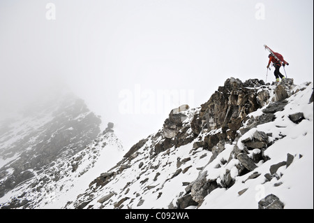 Backpacker climbs the West Ridge of Mt. Chamberlin in the Brooks Range, ANWR, Arctic Alaska, Summer Stock Photo