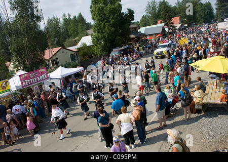 Spectators watch a Scottish band marching to bagpipe music during the Moose Dropping Festival Parade, Talkeetna, Alaska Stock Photo