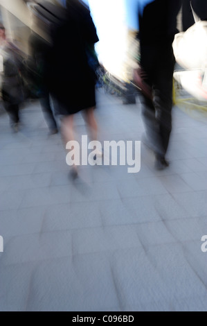 Man and woman in business clothing walking on a sidewalk, motion blur Stock Photo
