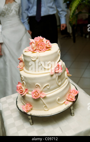 Traditional wedding cake in front of couple Stock Photo