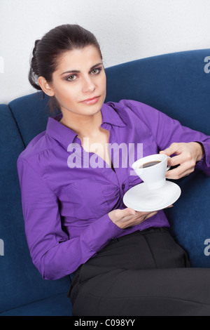 Pretty young businesswoman having a coffee break in the office Stock Photo