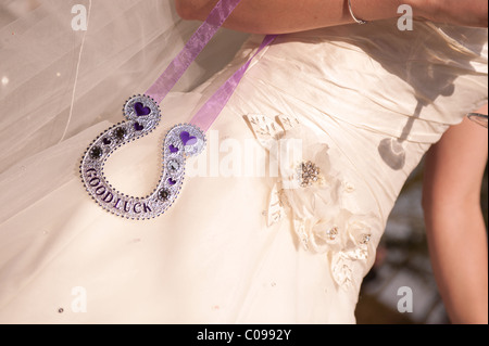 A bride in a wedding dress with a a traditional horseshoe good luck charm Stock Photo