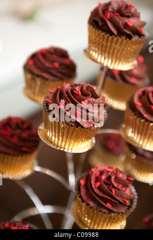 Chocolate swirl cup cakes in gold cases on a display stand Stock Photo