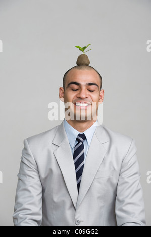 Businessman smiling with a sapling over his head Stock Photo - Alamy