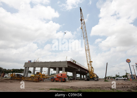 Crawler crane, boom lift, and other heavy equipment  at highway construction site in Raymondville Texas USA Stock Photo