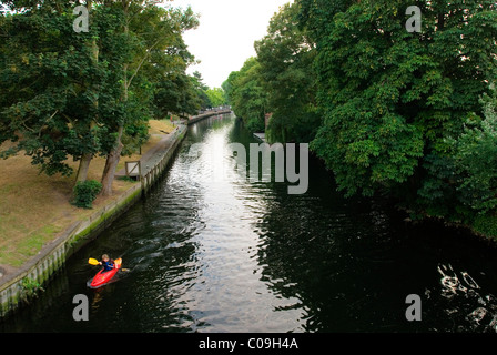 Lone person paddles their kayak down the River Wensum in Norwich, United Kingdom. Stock Photo