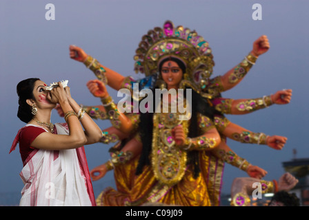 Woman blowing conch shell at Durga puja Stock Photo
