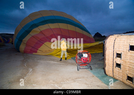 Hot air balloon being prepared for a flight over the tufa landscape of the UNESCO World Heritage Site Goreme, Cappadocia Stock Photo