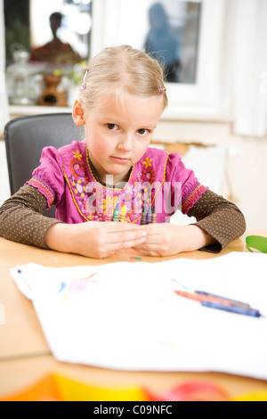 A girl holding her wax crayons Stock Photo