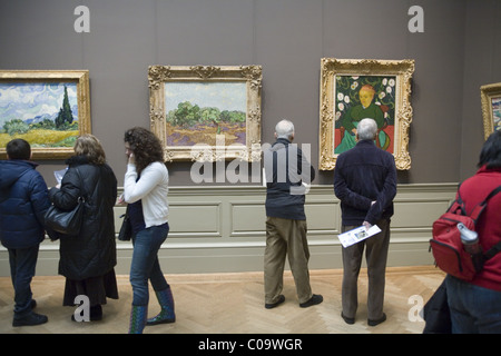 Museum goers linger in front of paintings by Vincent Van Gogh at the Metropolitan Museum of Art in New York City. Stock Photo