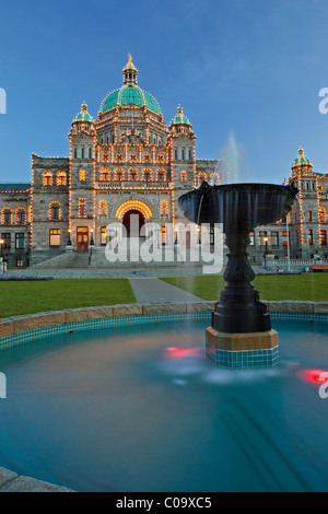 Illuminated fountain in front of the British Columbia Parliament buildings at twilight in the Inner Harbour in Victoria Stock Photo