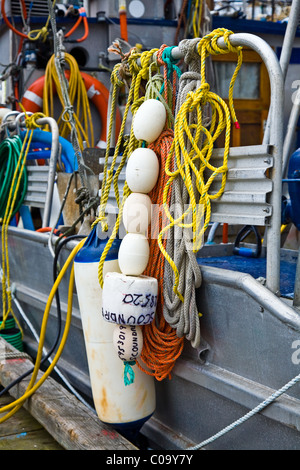 Abstract image of fishing boat equipment tied to a side rail of the boat