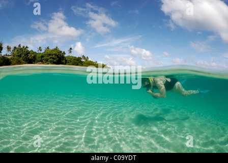 Middle aged women in one piece swim suit snorkelling over sandy on tropical beach. Ha`apai Group, Tonga. South Pacific Ocean. Stock Photo