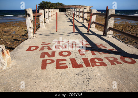 Danger sign on old pier in Cuba Stock Photo