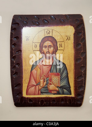 Jesus Christ holding Holy Book. Blessing gesture. Wall Decoration. House interior. Greece Stock Photo