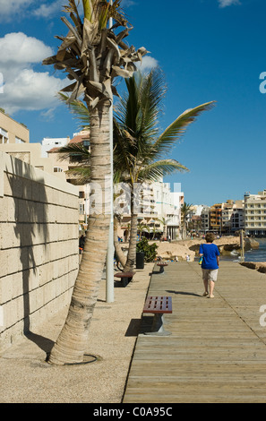 Senior female tourist walking along a boardwalk at El Medano Stock Photo