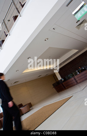 INTENTIONALLY BLURRED IMAGE OF A WOMAN ENTERING A MODERN OFFICE RECEPTION AREA Stock Photo