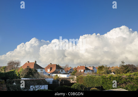 Cumulus clouds formed above English style houses Stock Photo