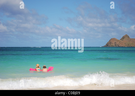 Couple floating on raft in ocean. Stock Photo