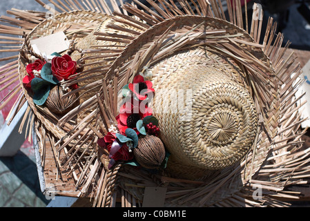 Tattered Straw hat and embellishments for sale on a Thai stall. Thailand S. E. Asia Stock Photo