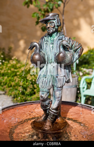 Close-up of a fountain. A man holding two birds under his arms. Stock Photo
