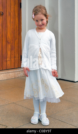 Christening Day. Five year old girl poses outside Russian Orthodox Church Abroad, Harvard Road,London W4, England, UK Europe Stock Photo