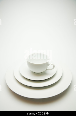 Cup on stack of white dishes Stock Photo