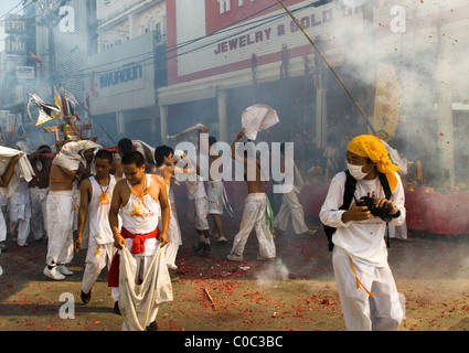 Fire crackers explosions during the colorful procession in the streets of Phuket city during the annual Vegetarian festival. Stock Photo
