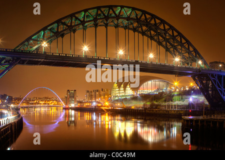 Tyne Bridge at night in Newcastle/Gateshead across the Tyne River (Millemium Bridge and Sage visible in background) Stock Photo