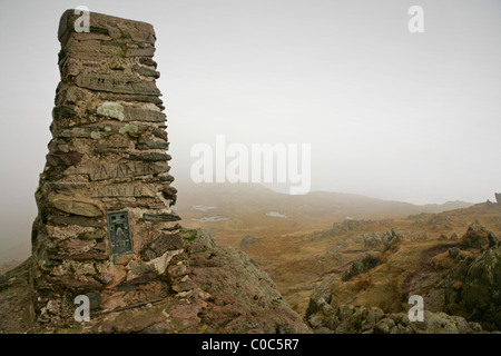 Cairn and Trig Point at the summit of Place fell, Lake District, Cumbria, on a cloudy day. Stock Photo