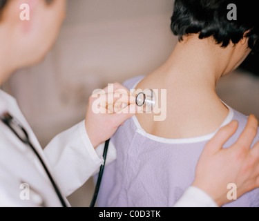 Doctor using stethoscope on patient Stock Photo