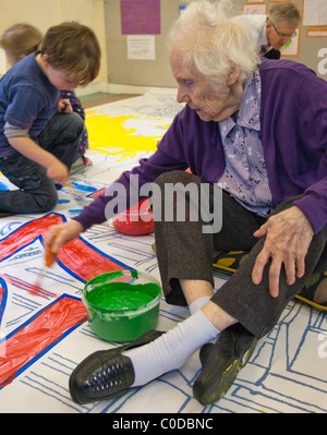 An Elderly Woman Painting with Children Stock Photo