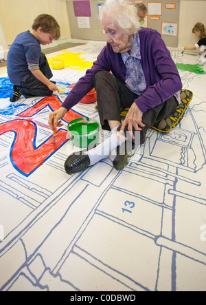 An Elderly Woman Painting with Children Stock Photo
