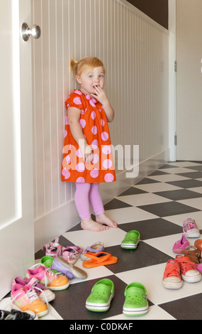 Little girl deciding which shoes to wear Stock Photo