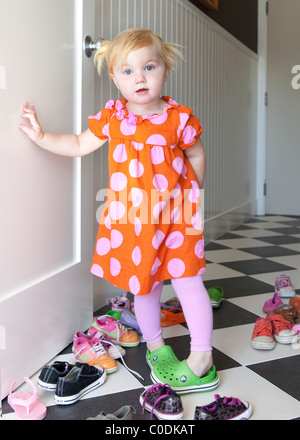 Little girl deciding which shoes to wear Stock Photo