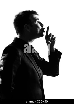 silhouette caucasian business man hushing silence profile finger on lips full length on studio isolated white background Stock Photo