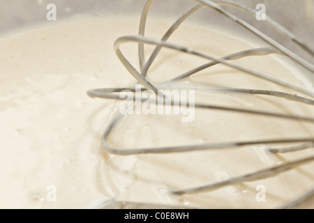Pancake batter mix with whisk close up abstract.