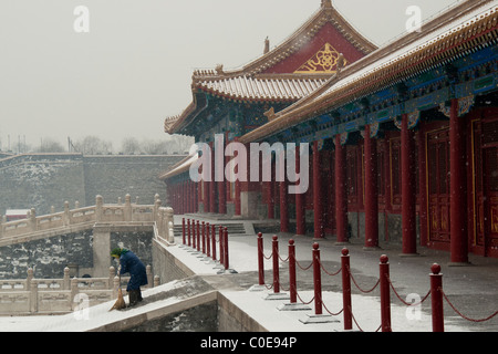 Attendant sweeping snow from the steps of The Supreme Harmony Gate of The Forbidden City, Beijing. Stock Photo