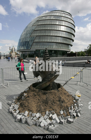 A Giant Drill Bit surfaces through the paving stones on the walkway at the foot of Tower bridge as part of an art installation Stock Photo