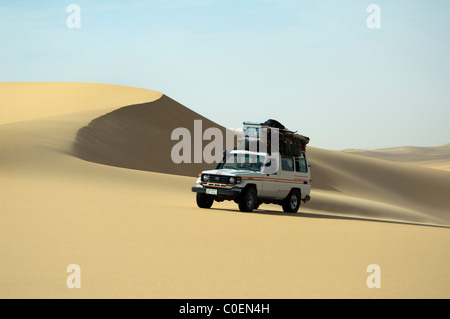 Lonely specialized desert vehicle traverses the sand dunes of the Western Desert in Egypti Stock Photo