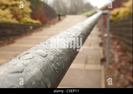 hand rail coated with rain droplets Stock Photo