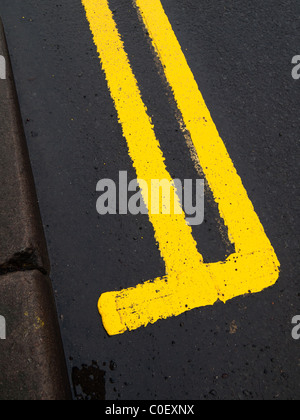 Road marking a newly painted double yellow line on a wet road Stock Photo