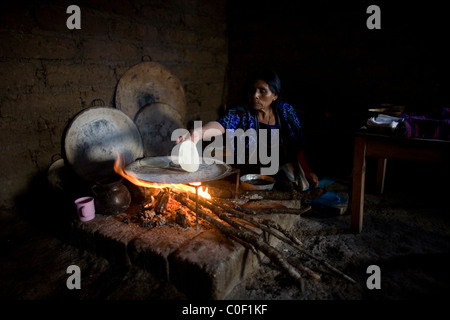 A Mayan Tzotzil woman makes corn tortillas for tourists in her home in Zinacantan, Chiapas, Mexico Stock Photo