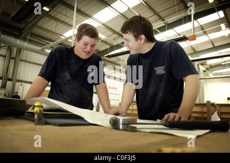 apprentice joiners looking at plans on bench Stock Photo