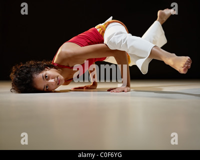 portrait of young adult latin american female doing yoga and capoeira in gym. Stock Photo