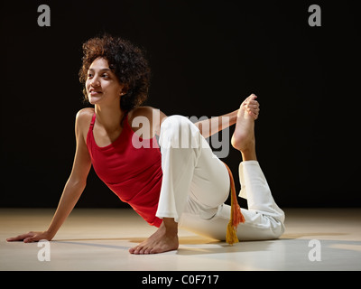 portrait of young adult latin american female doing yoga exercise in gym. Horizontal shape, full length, side view, copy space Stock Photo