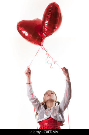 happy girl holding heart shaped balloons