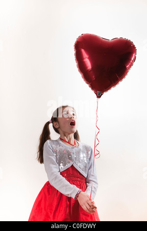 happy girl holding a heart shaped balloon